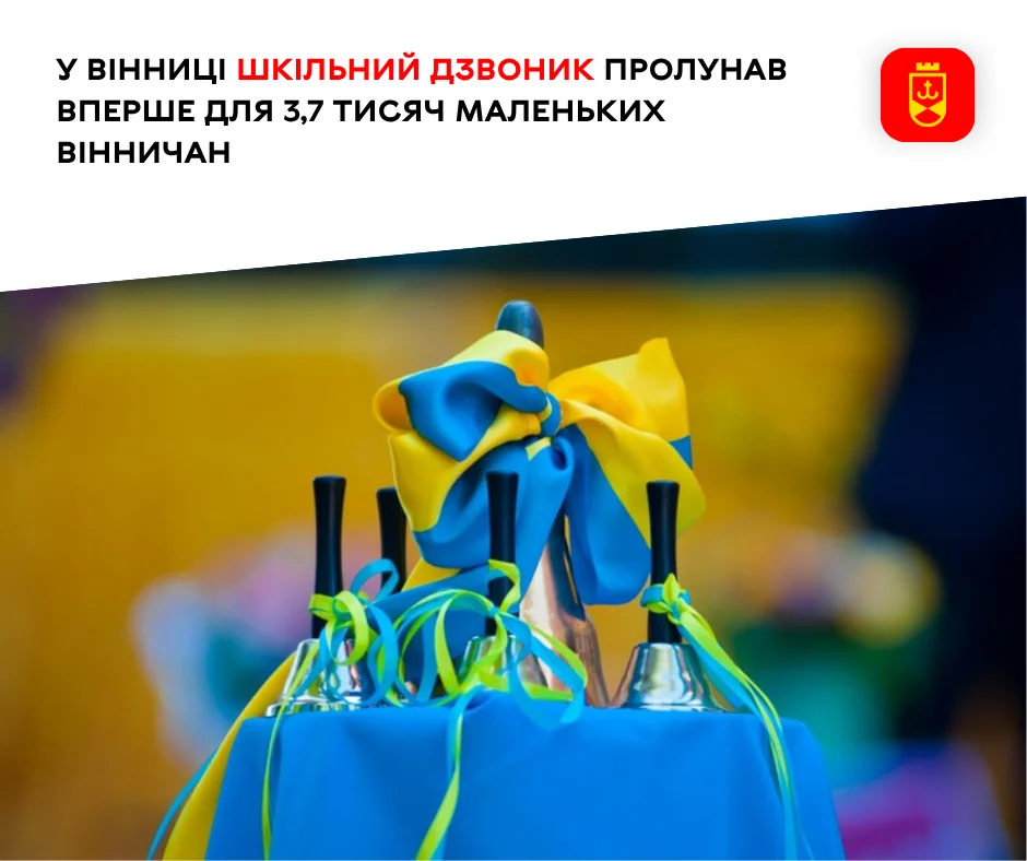 Шкільні дзвоники з жовто-синім бантом і стрічками на синій скатертині